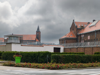 Wronki Prison, the largest correctional facility in the country, with historic red brick architecture, secure fences, and guard towers under a cloudy sky