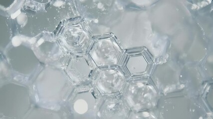 Transparent viscous liquid flowing over a cosmetic or scientific hexagonal molecular structure. Extreme macro shot showing the fluid dynamics and abstract beauty of a clear gel substance - Powered by Adobe