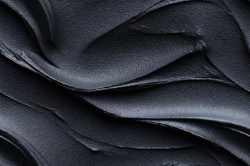 Obraz premium Deep black cosmetic clay mask texture background, full frame detail showing abstract wavy pattern, seamless for design concept.