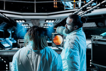 Team of cosmonauts doing brainstorming during Mars expedition for future of mankind. Teamworking astronauts talking in spaceship, exploring red planet to support human life beyond Earth