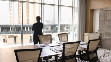 Back view businessman wear formal suit stand by panoramic window
