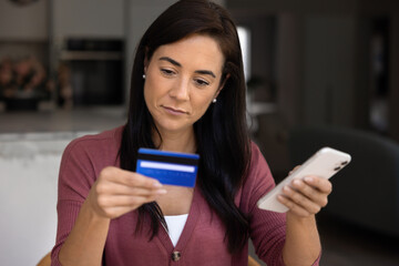 Serious Hispanic online store customer woman making online payment