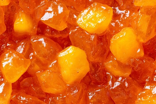 Closeup of orange fruit jam abstract seamless pattern. Food background texture with glistening candied apricot pieces.