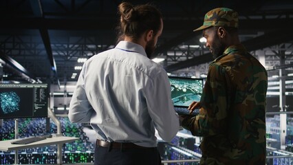 Army operators in data center using laptop to run drone control software, looking at mission map overlay. Military experts doing strategic deployment of autonomous aerial vehicles
