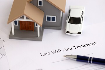Generic toy house with car and Last will and testament with pen on table close up