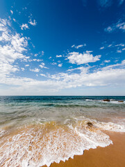 Low angle view of sandy beach and sea under sunny blue sky