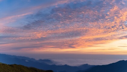 Obraz premium Morning sky with glowing altocumulus clouds and distant mountains at sunrise 