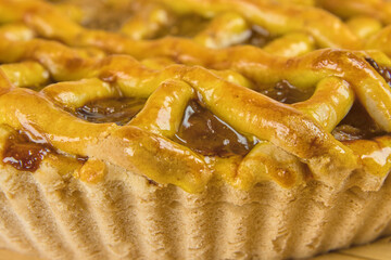 Photograph of an apple pie on a wooden table in close-up with copy space. Studio photography.