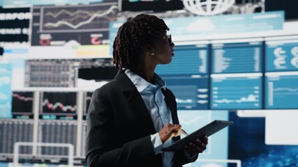 Business specialist using tablet to review performance dashboards metrics during corporate strategy planning session. Management executive evaluating annual report data using device, camera B