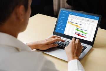 Project planning software for modish business project management on the computer screen showing timeline chart of the team project
