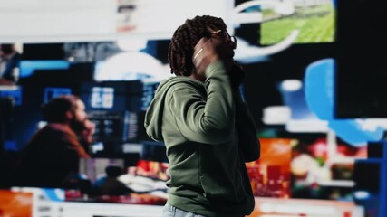 Young woman uses smartphone to do telephone call with mate, discussing online videos. Teenager uses phone to call friend and talk about shared media consumption, colorful multimedia backdrop, camera B