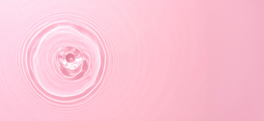 Minimalist scene of calm pink water with a single soft ripple