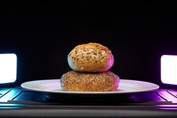 Single bread bun close up on plate with colorful studio lighting