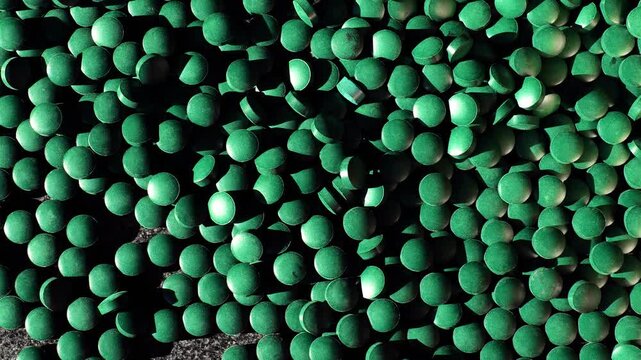 Green algae capsules background in the suns rays. Algae superfood. Algae in diet and nutrition. 4k footage