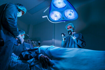 Team of surgeon doctor using defibrillator to give electrical shock to patient heart who is suffering from cardiac arrest in emergency surgical room for healthcare