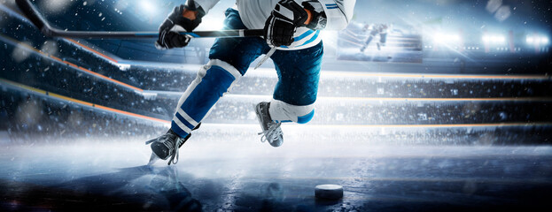 Hockey skates, stick and puck close-up. Hockey player in ice arena. The large ice hockey arena is full of fans. Hockey player in action. Ice. Stadium © Ruslan Shevchenko