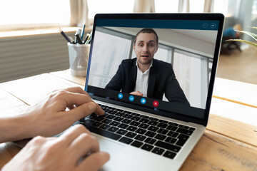 Closeup businessman talking to partner on video call using notebook