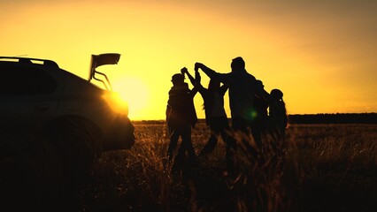 Family, parents children having party in park next car. Family, parents kids are relaxing dancing joyfully, sunset park. Mom dad children having fun in field, travel camping, car trip, dancing party