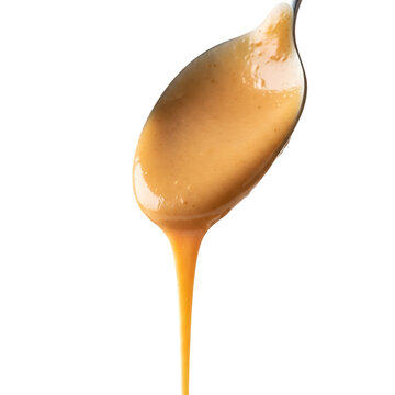 Thick peanut butter sauce dripping from spoon