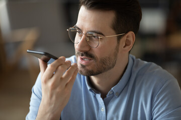 Closeup portrait young businessman speaking on phone using voice app