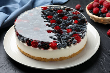 Delicious cheesecake with berries on black textured table, closeup