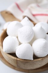 Delicious meringue cookies in bowl on white table, closeup
