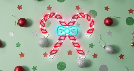 Image of flickering christmas sugar cain over christmas decorations