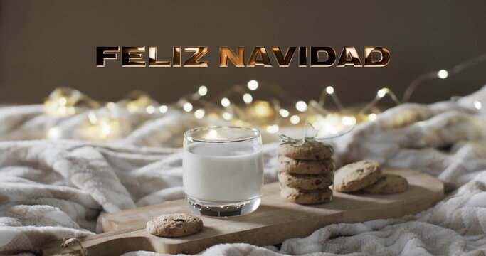 Image of feliz navidad text over cookies and milk