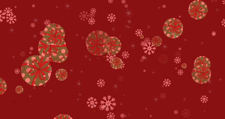 Multiple snowflakes and christmas gift icons falling against red background