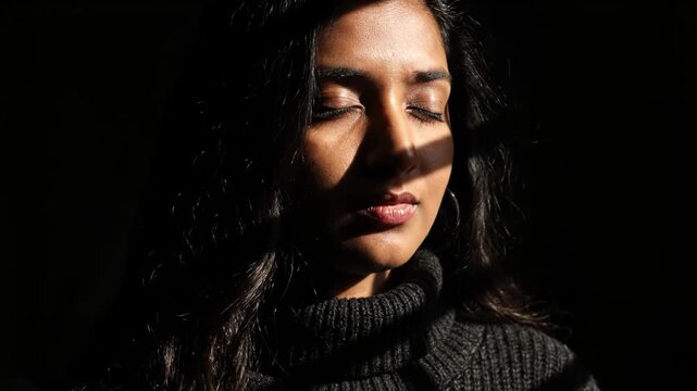 Portrait of a young woman with eyes closed, bathed in dramatic sunlight and shadow, conveying a sense of introspection and peace vector illustration