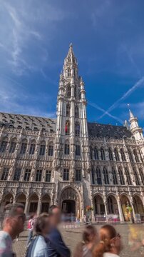 Timelapse hyperlapse of Town Hall (Hotel de Ville) on the Grand Place in Brussels, Belgium. Looking up at the Gothic tower and facade. A UNESCO World Heritage Site and major tourist destination
