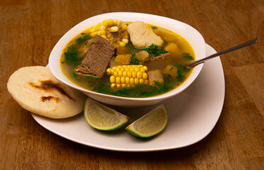 Traditional Venezuelan soup with arepa and lime on rustic table