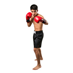 Focused teenage boxer in red gloves and black shorts standing in a fighting stance against a dark studio background, ready for a match.