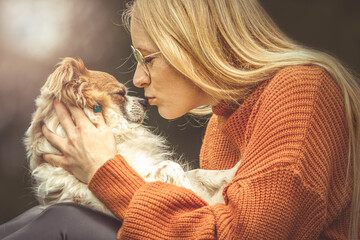 Tender moment between woman and Chihuahua dog, autumn light and emotional connection