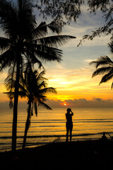 Fototapeta premium Sunrise with silhouette woman and coconut
