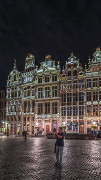 Night hyperlapse of the illuminated Grand Place Guilds facade in Brussels, Belgium. Historic art guild associations in Baroque architecture timelapse, with people walking on the UNESCO-listed square