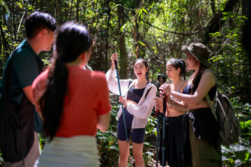 Group of friends discussing while hiking in forest