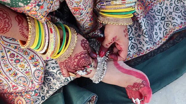 Indian woman wearing colorful bangles and anklets, dressed in traditional attire for festive celebrations like marriage, Teej, or Karwa Chauth