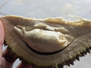 A close-up view of the creamy white flesh of a durian fruit, revealing its unique texture and segments.