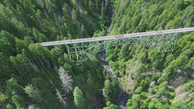 Abandoned Vance railroad bridge in western Washington. Rotating, high angle flyover shot of the bridge shows the damaged tracks, with the canyon below.