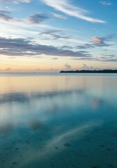 Fototapeta premium Serene Seascape at Dawn: Capturing the calm beauty of the tranquil ocean at dawn, the sky blazes with soft pastel hues. The glassy water mirrors the heavens.