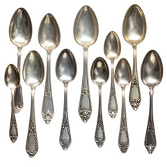 Collection of antique silver spoons arranged in a dark  setting.