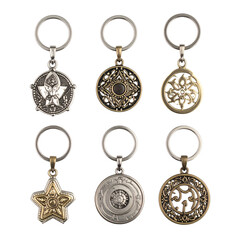 Six ornate metal keychains showcase diverse decorative designs against black.