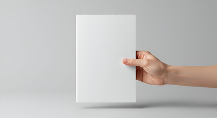 Elegant display of a blank white book cover held by a hand for creative design