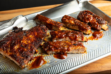 A savory rack of barbecue ribs cut pieces Ready to eat cooked to perfection A savory rack of barbecue ribs Ready to eat cooked to perfection served on a metal tray