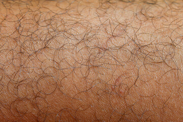 close up of a man's brown skinned leg with fine hair
