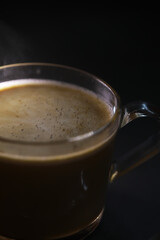 Steaming Hot Cup of Espresso in Clear Glass Mug with Dark Background