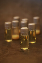 Small Glass Vials with Yellow Liquid on a Brown Surface in Soft Focus