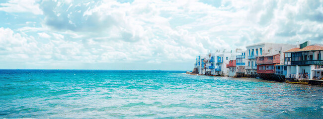 Charming greek island buildings line a sparkling blue sea
