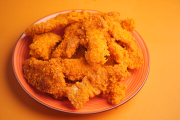 Crispy fried chicken strips on a colorful plate